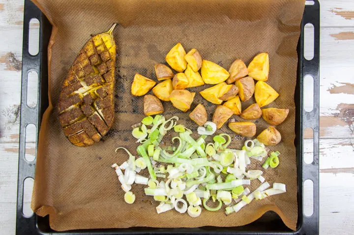 oven-roasted eggplant, potatoes and leek on baking tray