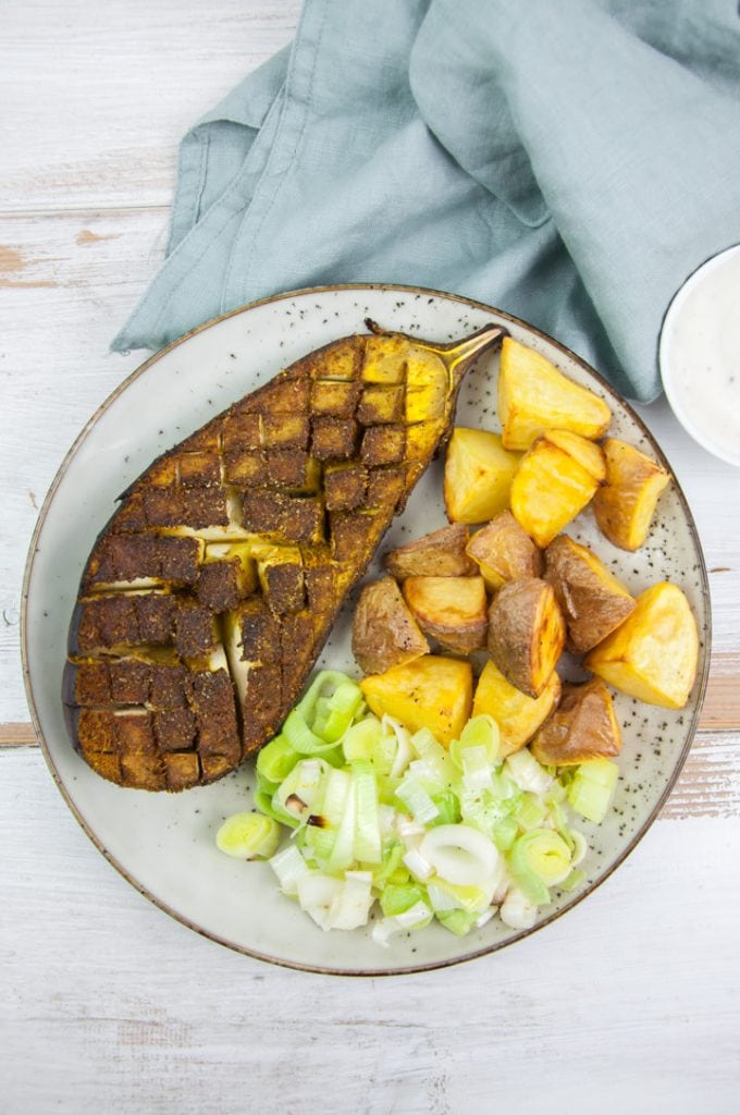 oven roasted eggplant with ras el hanout seasoning served with potatoes and leeks