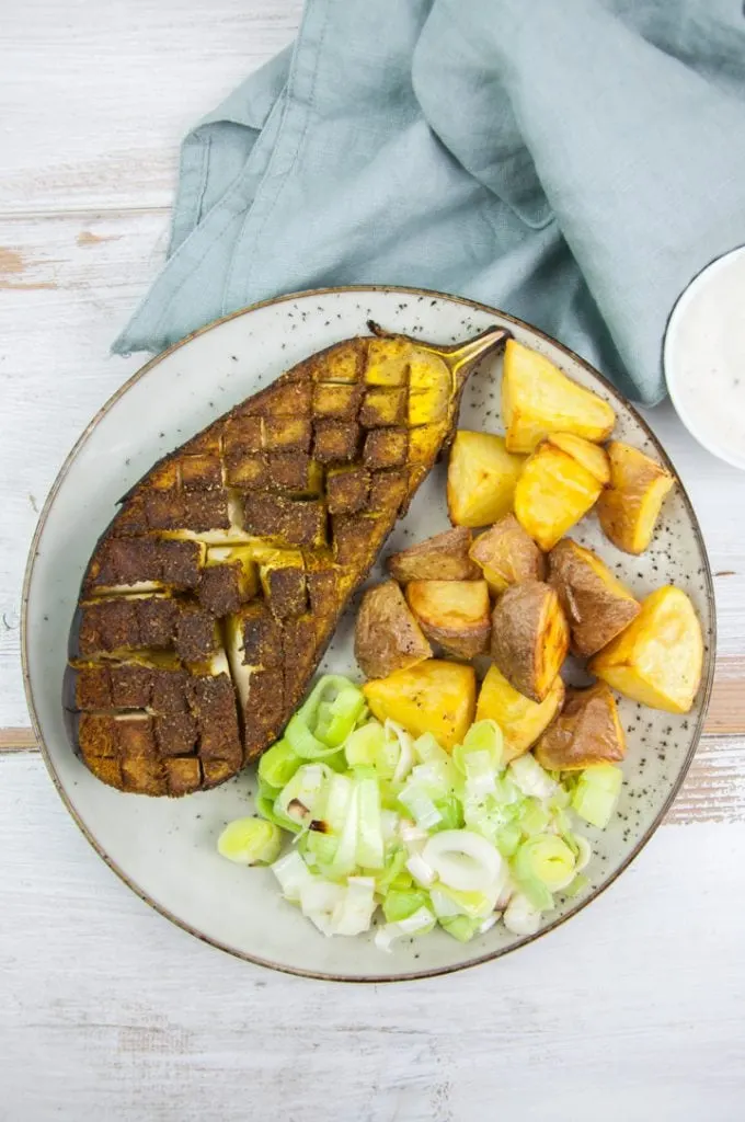 oven roasted eggplant with ras el hanout seasoning served with potatoes and leeks