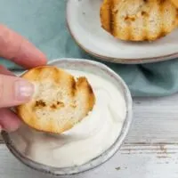 dipping toasted bread in vegan aioli