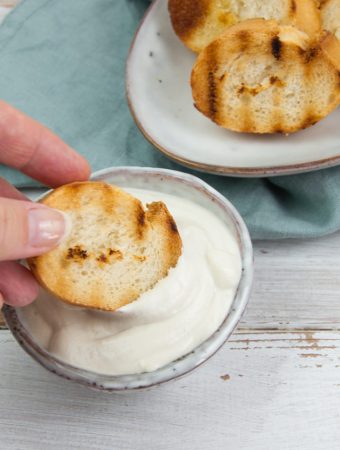 dipping toasted bread in vegan aioli