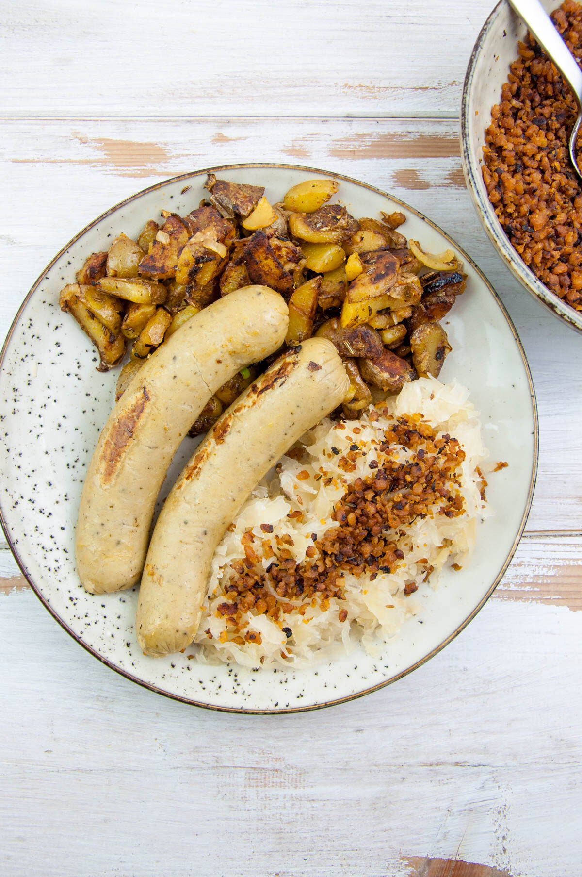 sauerkraut with vegan bacon bits, vegan sausages and roasted potatoes