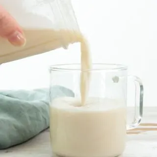 pouring sesame milk into a glass