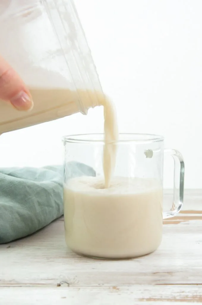 pouring sesame milk into a glass