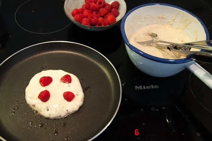 making raspberry pancakes in a pan