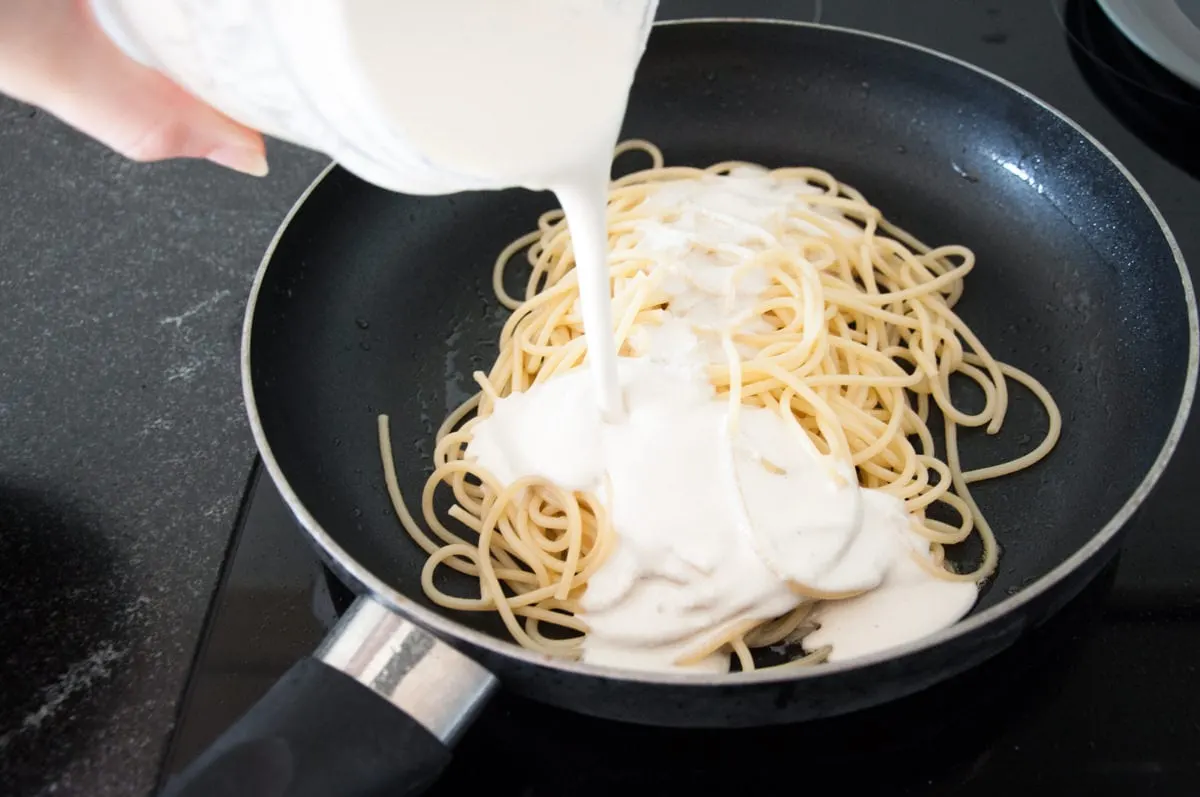 combining spaghetti and cashew sauce