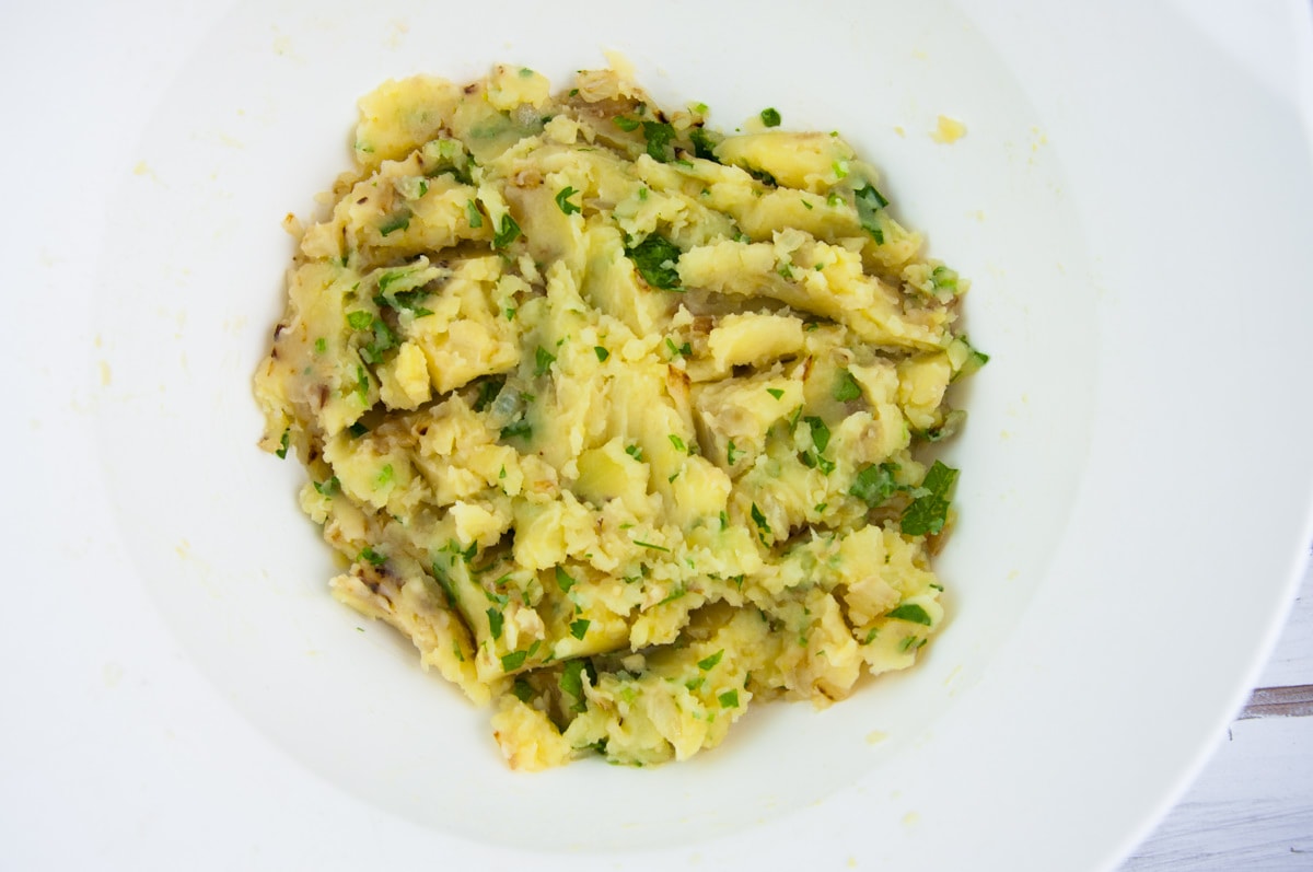 potatoes, onions, garlic, parsley, salt mixed in a bowl