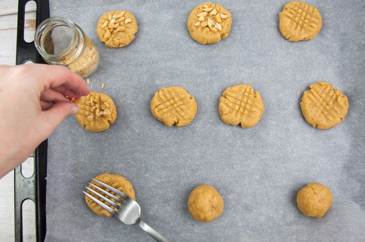 topping peanut butter cookies with salted peanuts