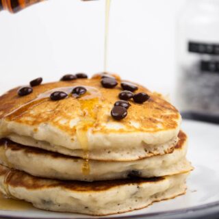 Vegan Chocolate Chip Pancakes drizzled with maple syrup