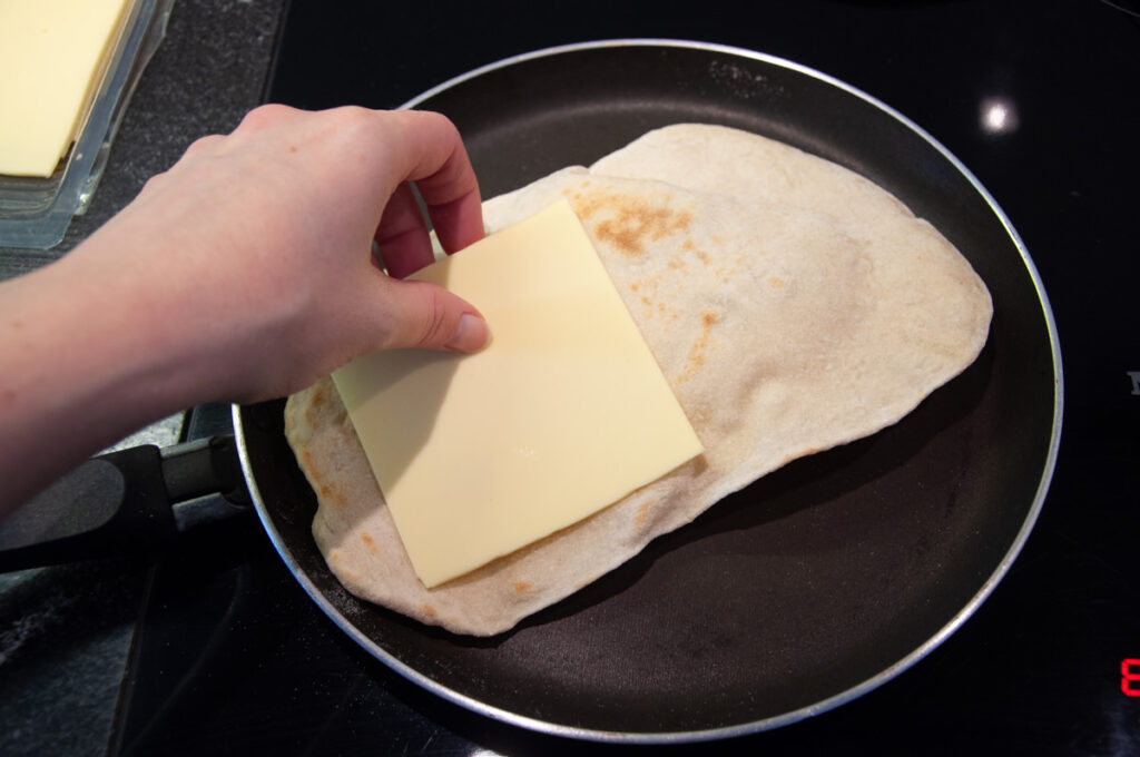 naan in a pan with a slice of cheese