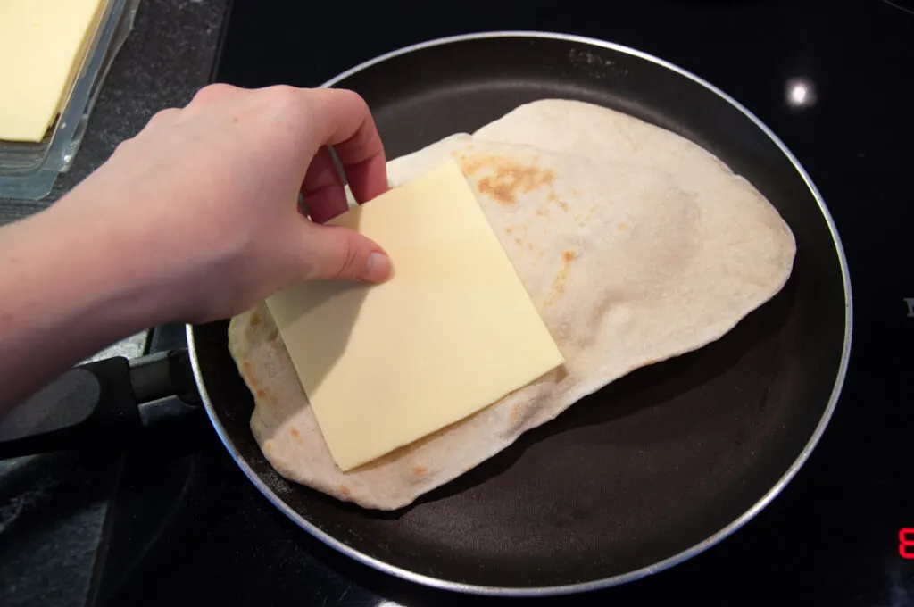 naan in a pan with a slice of cheese