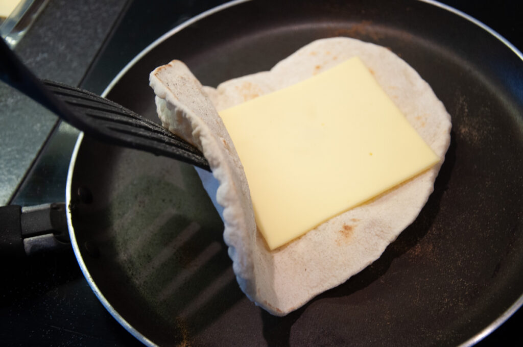 naan in a pan with a slice of cheese