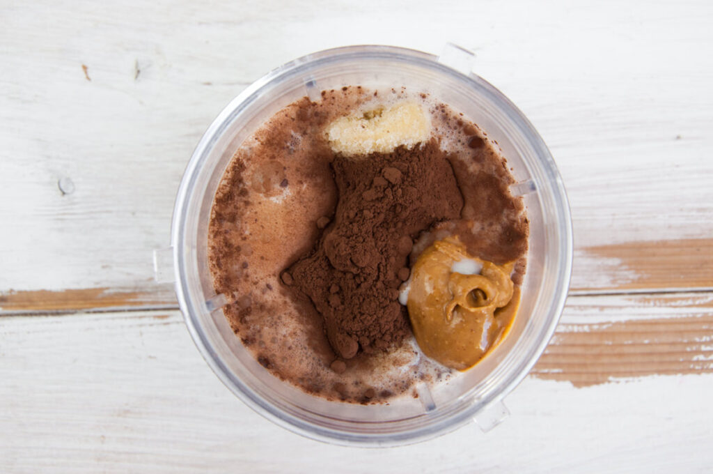 frozen bananas, plant-based milk, cocoa powder, peanut butter and salt in blender