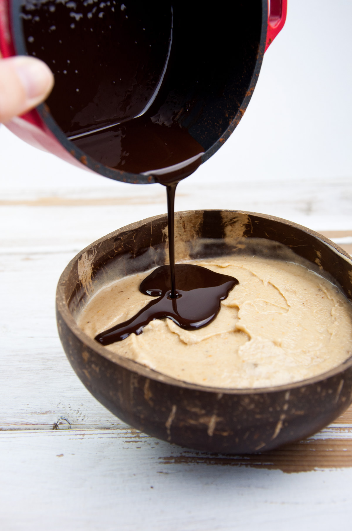 pouring chocolate sauce over nice cream