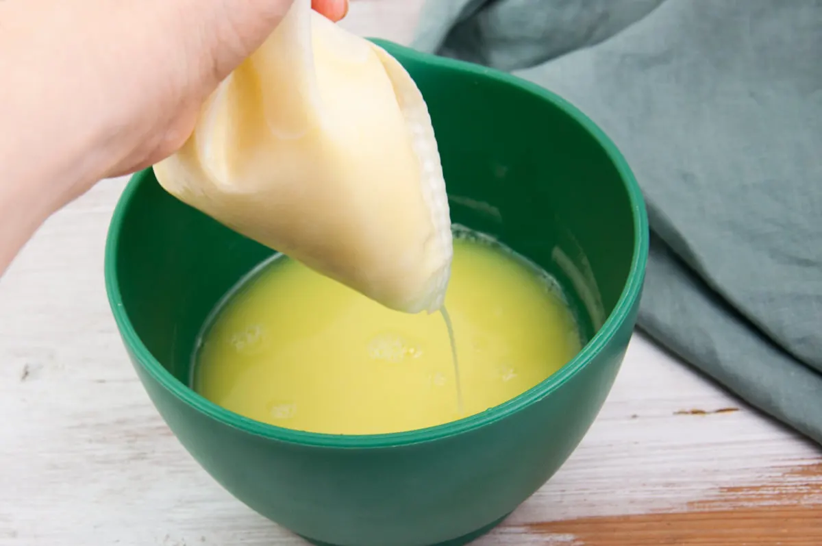 pouring ginger shot through nutmilk bag