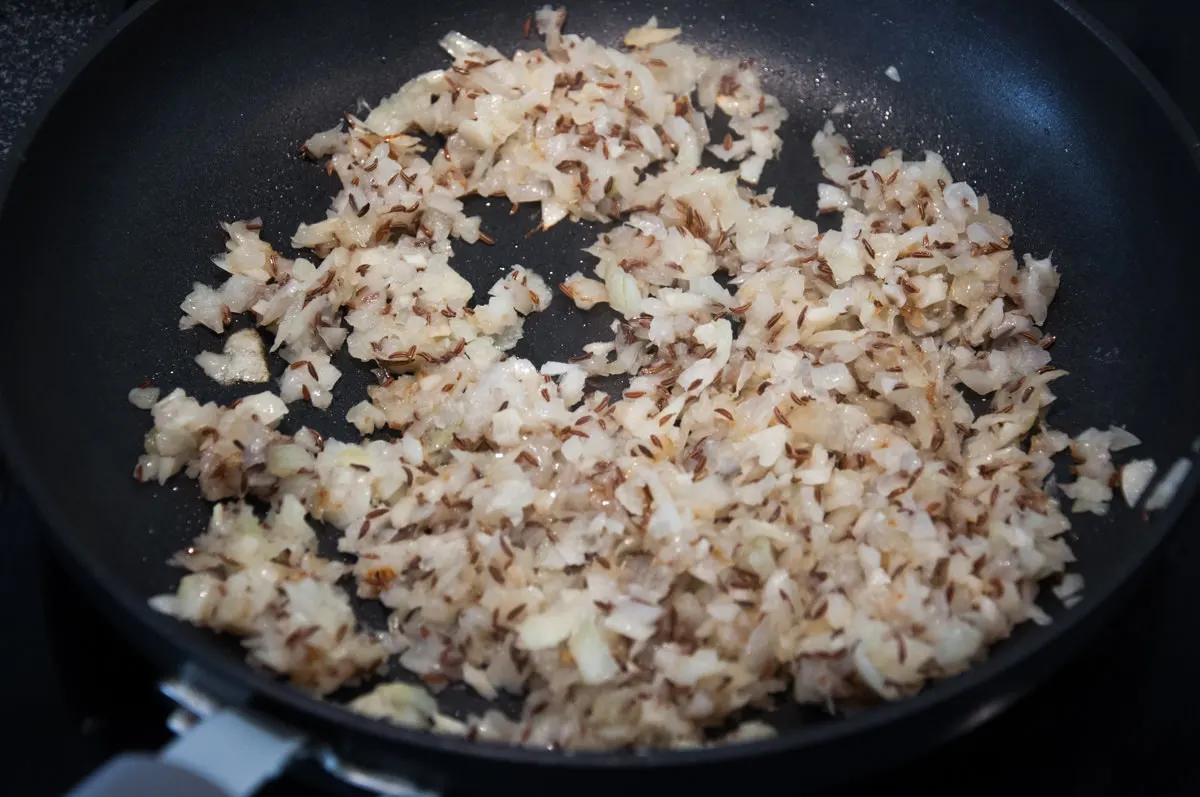 onion, garlic, and cumin in pan