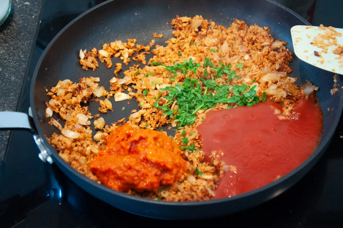 soy granules, onion, garlic, parsley, ajvar, and tomato paste in pan