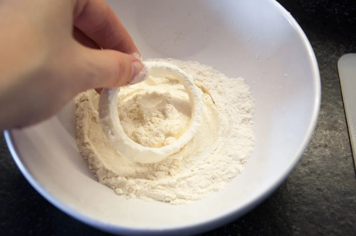 dipping onion ring in flour coating