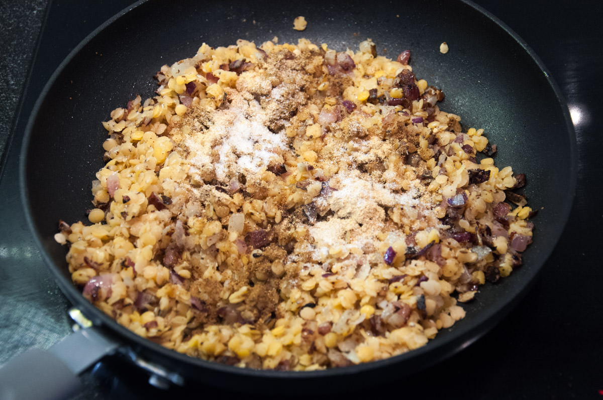 onions, red lentils, and spices in pan