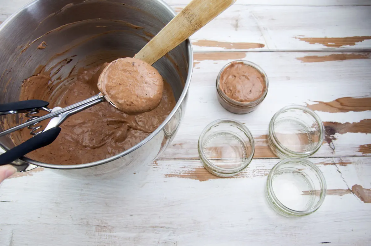scooping chocolate mousse into jars