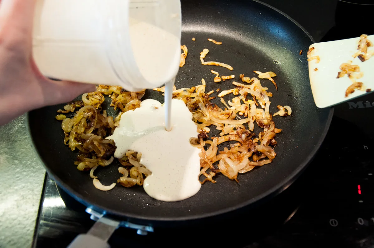 adding cashew cream to caramelized onions